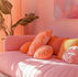 Un salon Airbnb lumineux et coloré, décoré dans des tons roses et orangés, illustrant l’impact d’un aménagement différenciant sans gros budget.